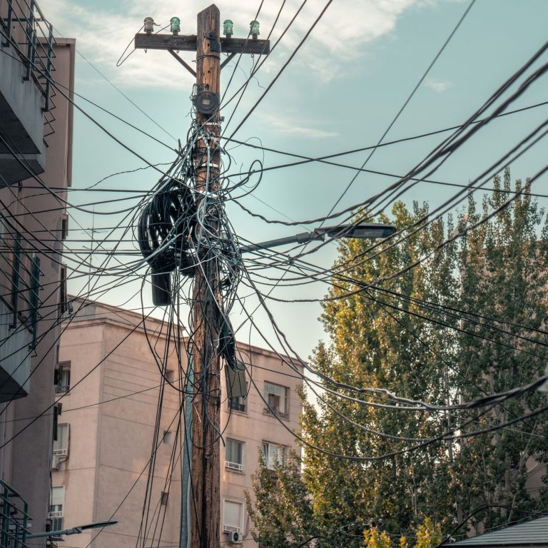 Sűrűn futó elektromos légvezetékek egy utcán