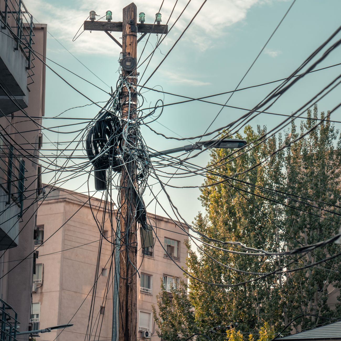 Sűrűn futó elektromos légvezetékek egy utcán
